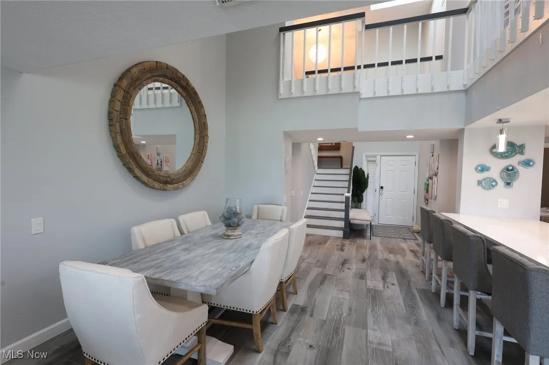 Dining area with stairs, wood finished floors, and baseboards