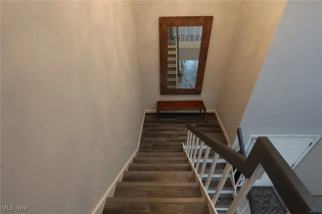 Stairs with wood finished floors and baseboards