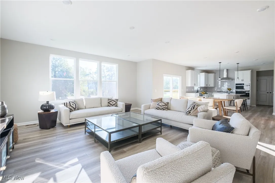Living area with light wood-style flooring and recessed lighting