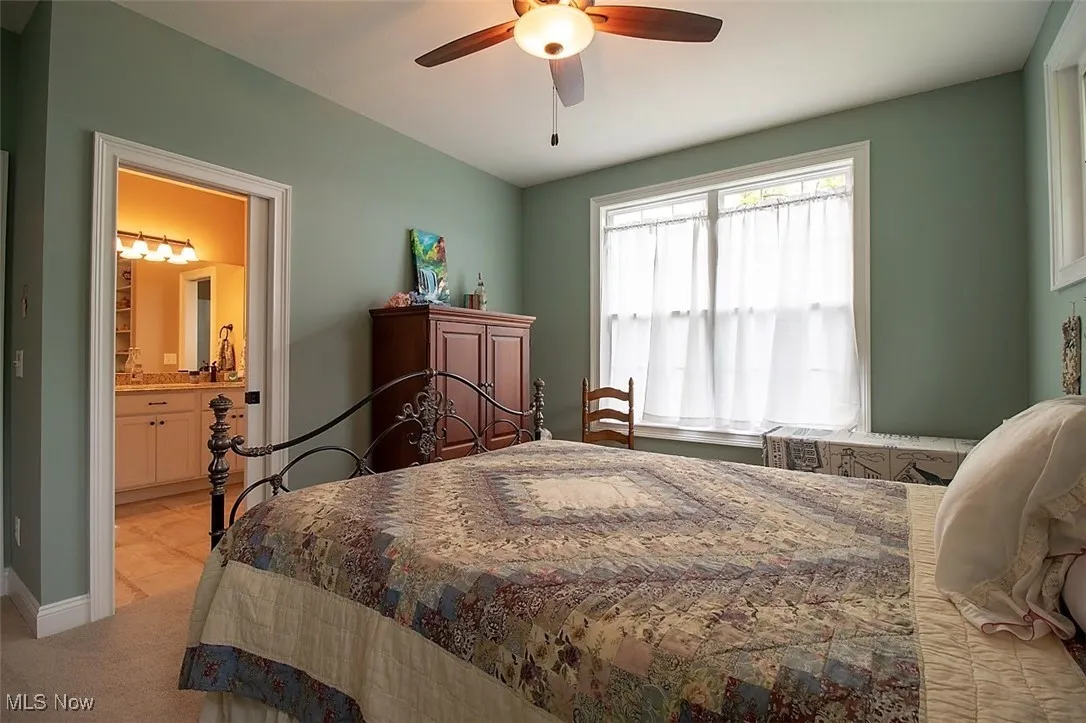 Virtually staged Second Bedroom featuring light carpet, Jack & Jill  bathroom, and ceiling fan