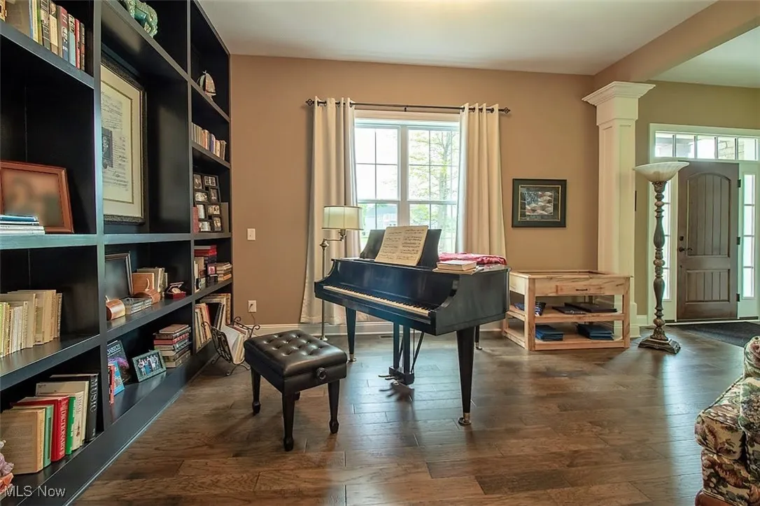 Virtually staged, Dining/Music  room featuring dark wood flooring and decorative columns