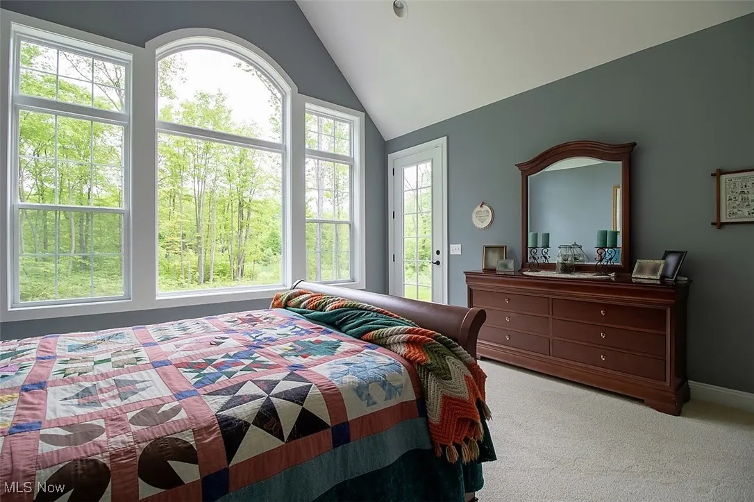 Virtually staged Carpeted master bedroom with vaulted ceiling and access to outside back porch