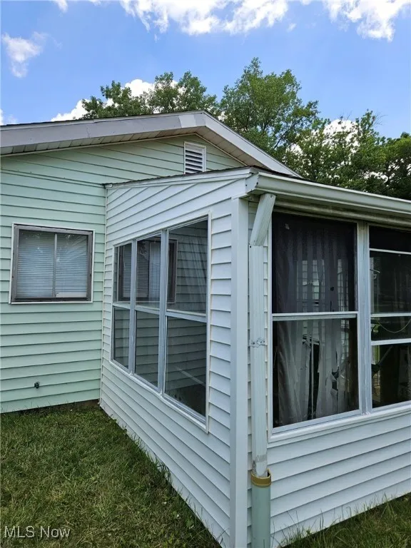 View of side of property with a sunroom