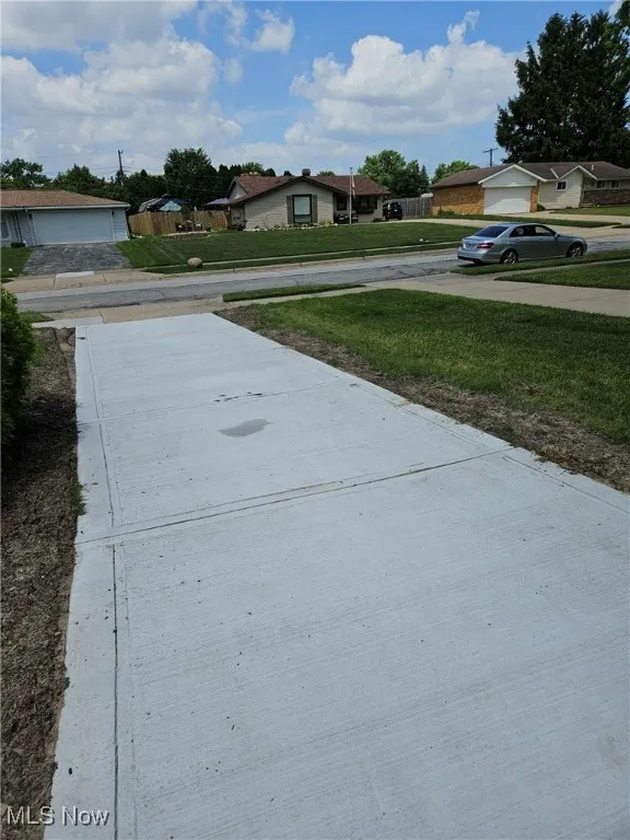 View of green lawn with a residential view