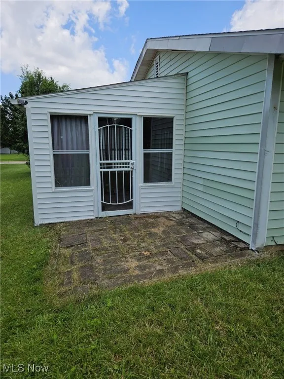 Rear view of house with a yard and a patio area