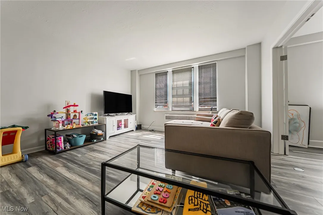 Living room with wood finished floors and radiator