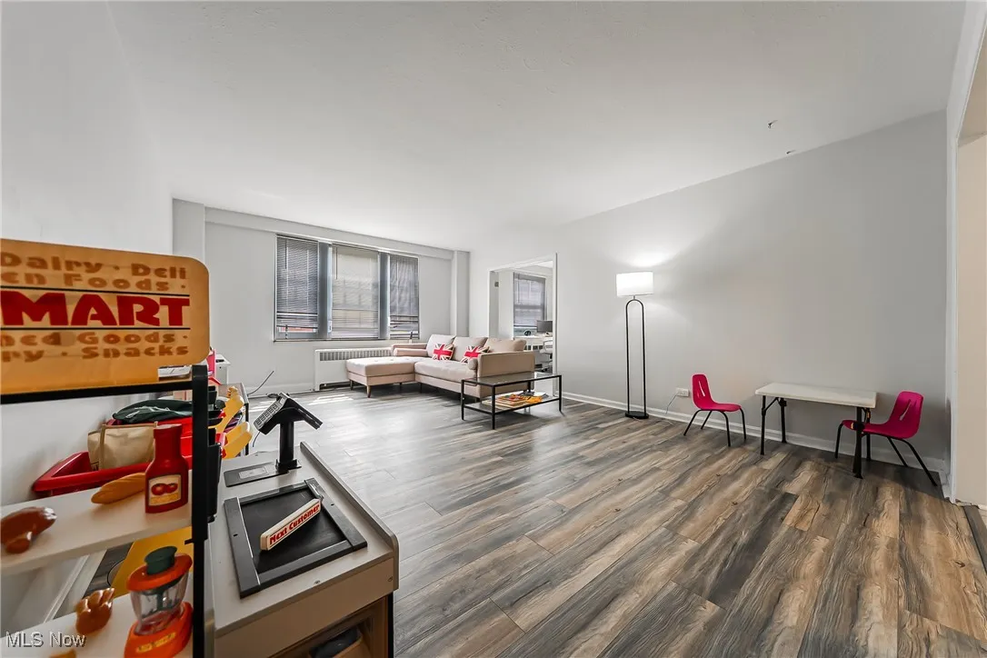 Living area featuring wood finished floors and radiator