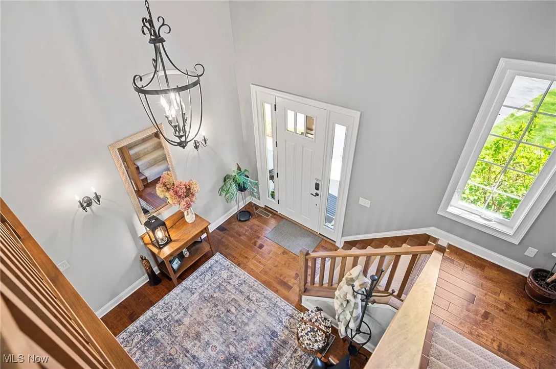 Entrance 2-story foyer featuring hardwood, stairs, and a chandelier