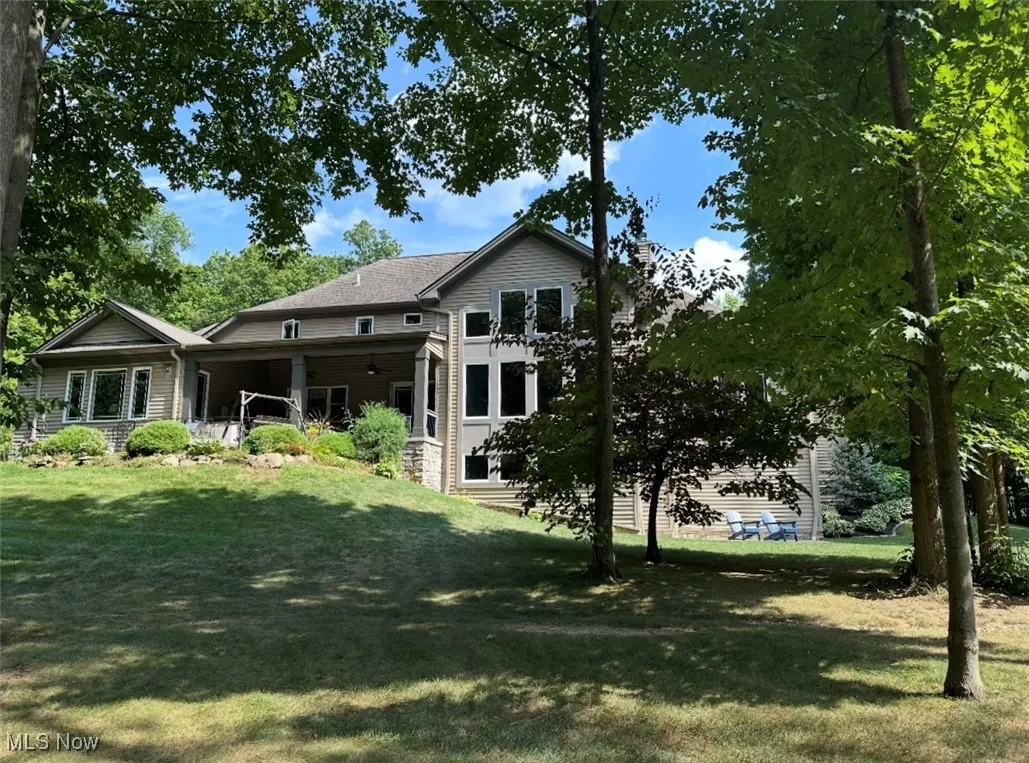 Back of house featuring a lawn and a patio