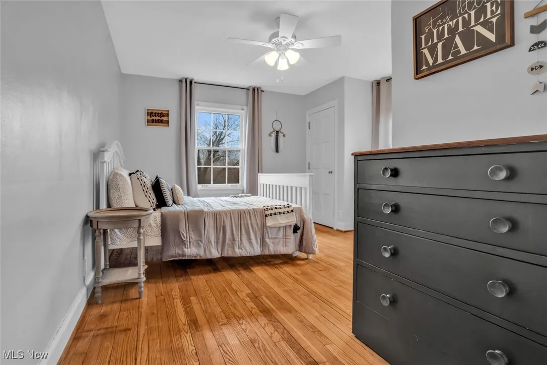 Bedroom with light wood-style flooring, baseboards, and ceiling fan