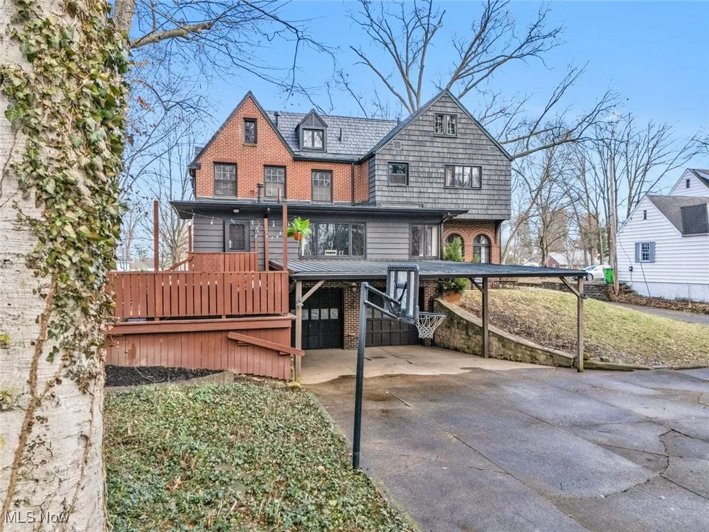 Rear view of house with driveway, brick siding, and a carport