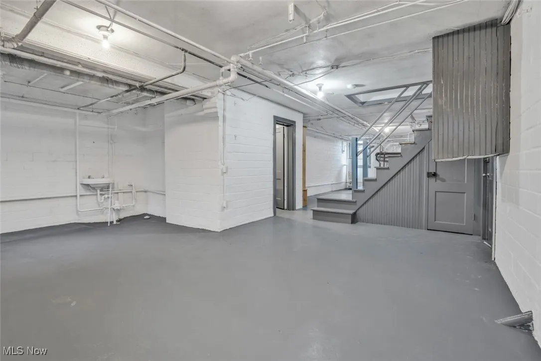 Below grade area featuring stairs and concrete block wall