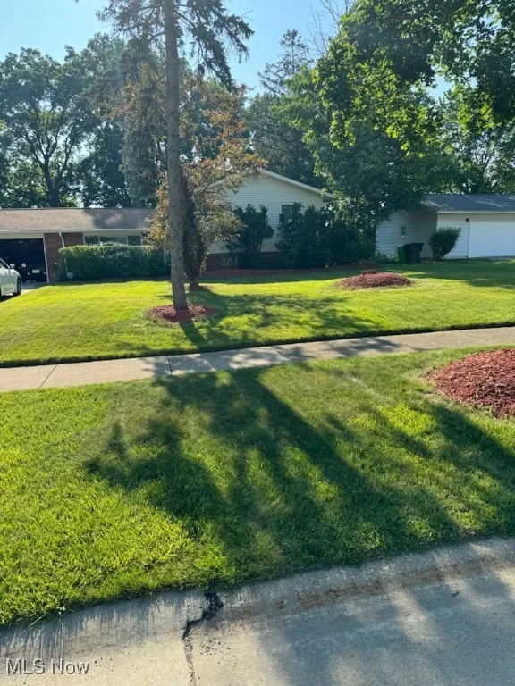 View of green lawn featuring a garage
