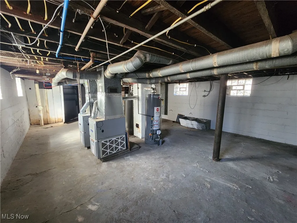 Basement featuring water heater and heating unit