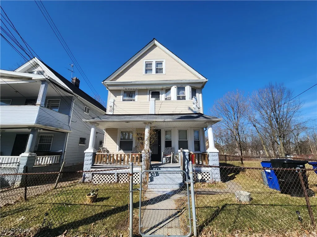 View of front facade featuring covered porch and a gate