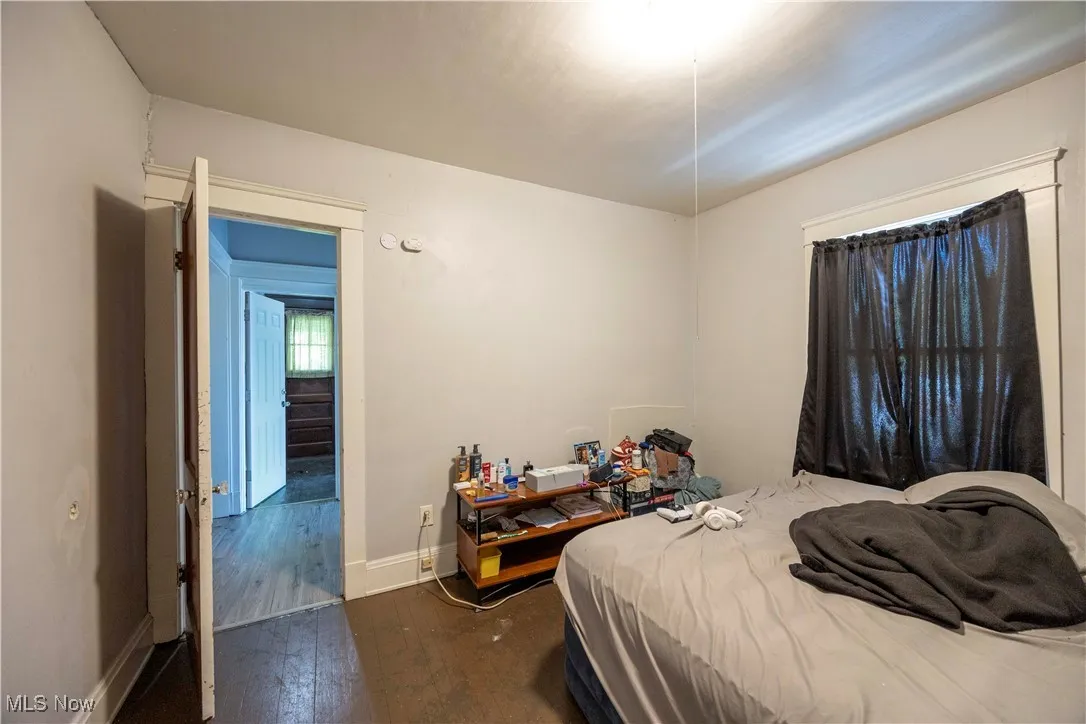 Bedroom with hardwood / wood-style flooring and baseboards