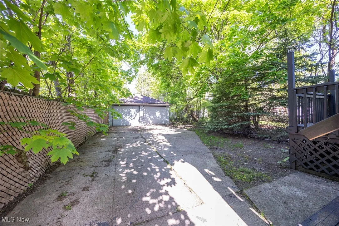 View of yard featuring a garage, fence, and an outdoor structure