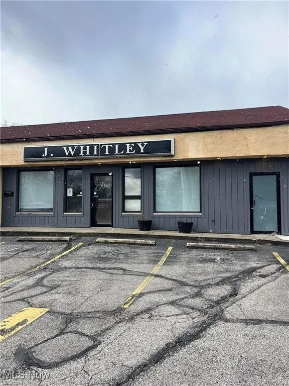 View of building exterior with uncovered parking