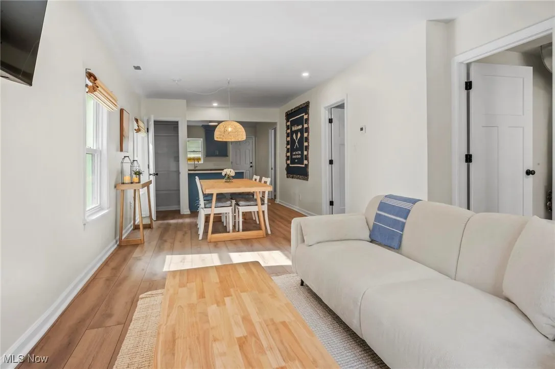 Living room featuring light wood finished floors, baseboards, and recessed lighting