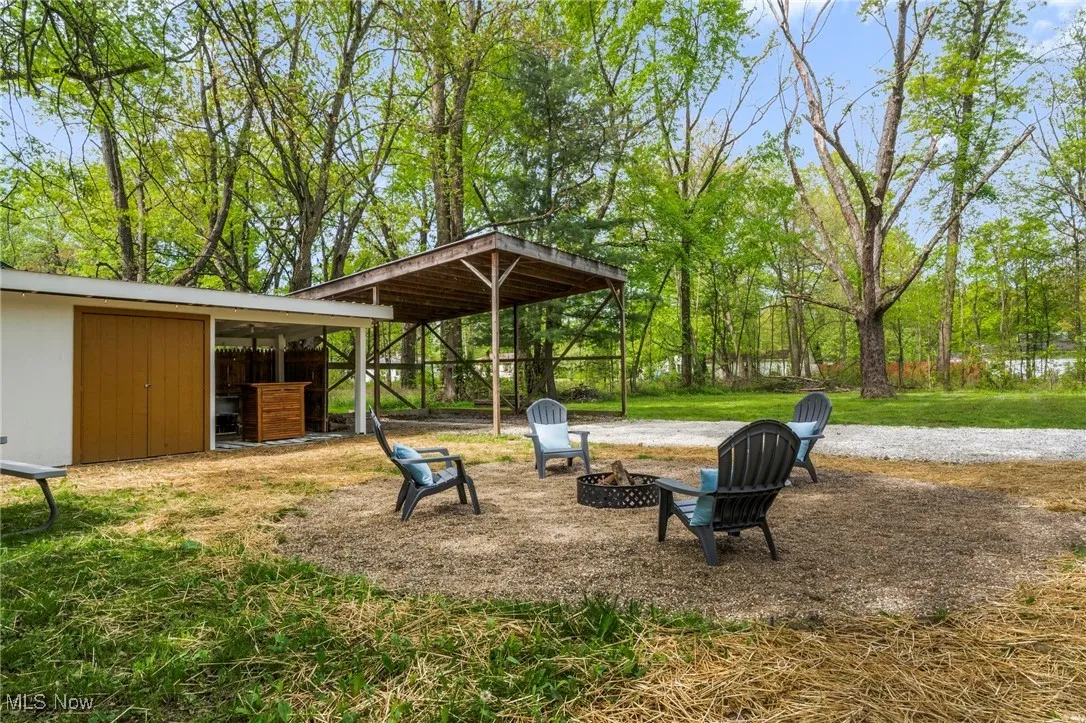 Surrounding community featuring a fire pit, an outbuilding, and a lawn