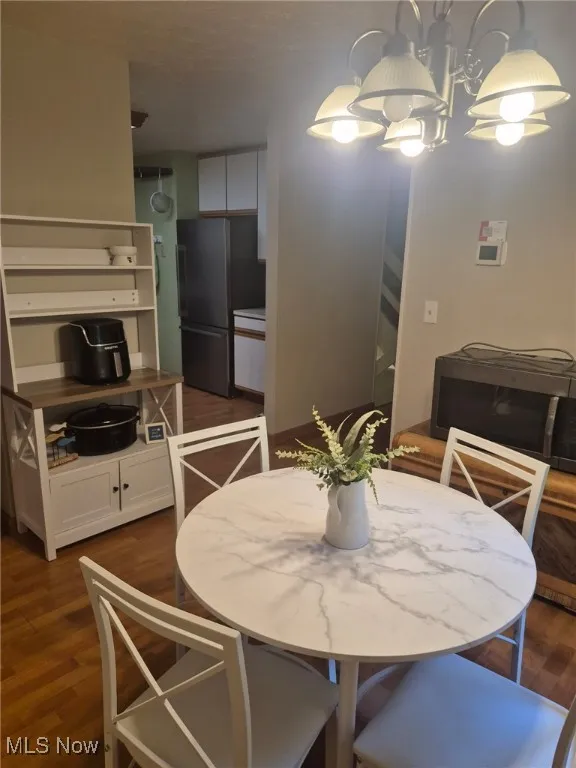 Dining space with dark wood-style floors and a chandelier