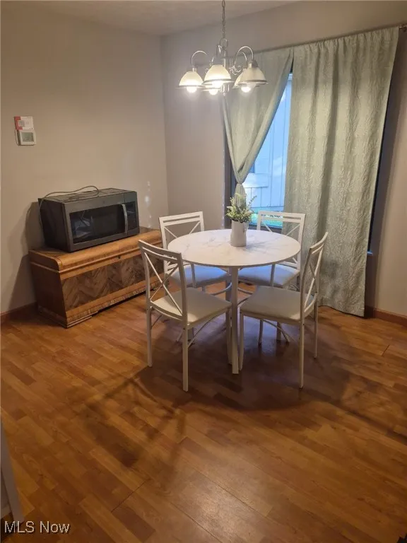 Dining room featuring wood finished floors and a chandelier