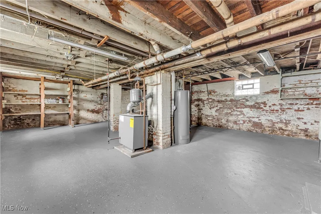 Basement with gas water heater and a heating unit