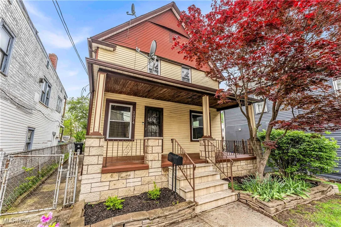 View of front of home featuring a porch, a gate, and fence