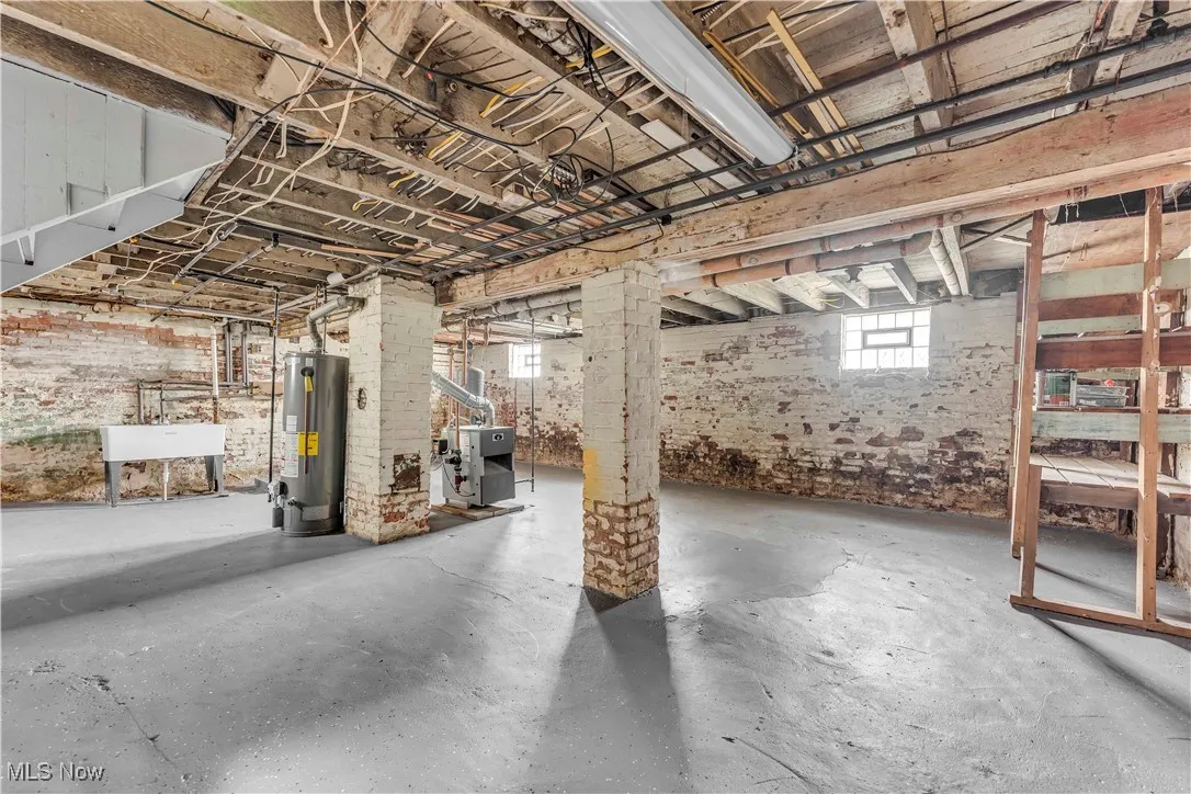 Below grade area with water heater, a sink, and a heating unit