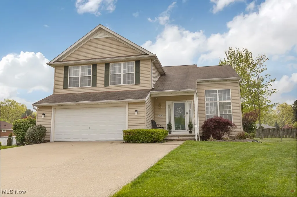 View of front of home with concrete driveway and an attached garage