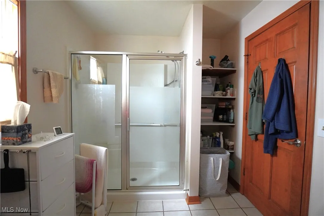Full bath featuring a stall shower and tile patterned flooring