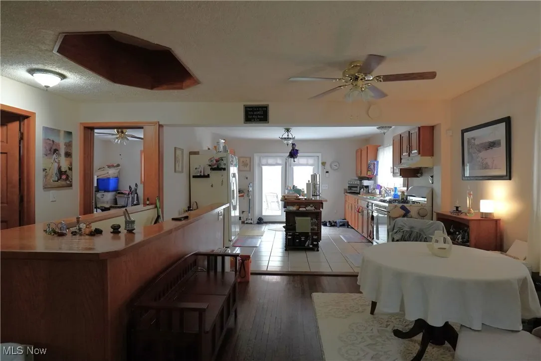 Dining space with ceiling fan and light wood-style flooring
