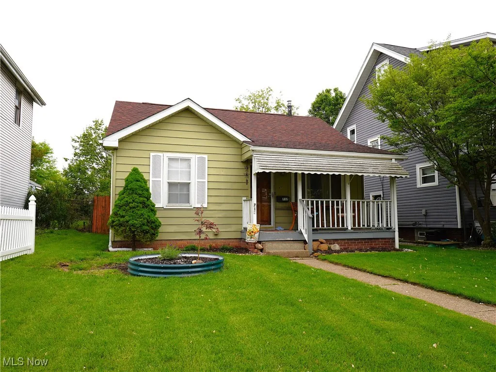 View of front of home featuring covered porch and a shingled roof