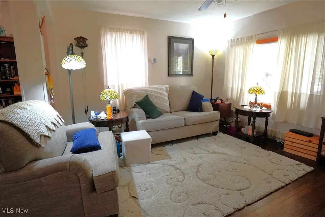 Living area with wood finished floors and ceiling fan