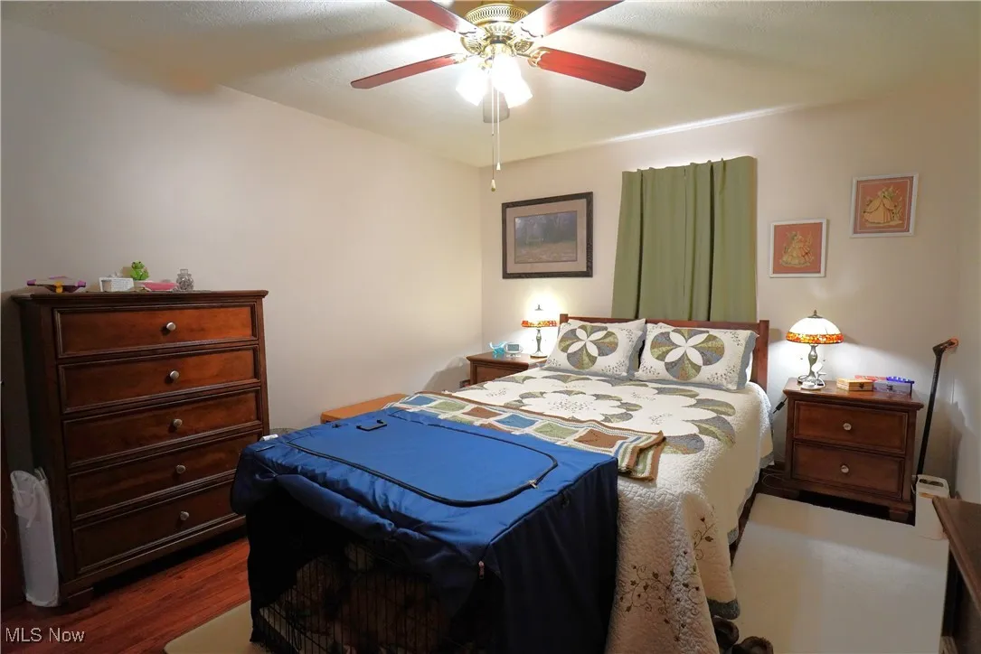 Bedroom featuring dark wood-style flooring and a ceiling fan