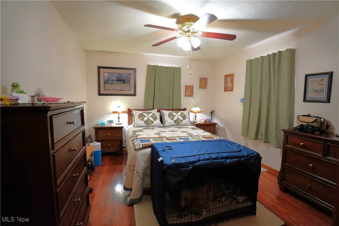 Bedroom with dark wood-style floors and ceiling fan