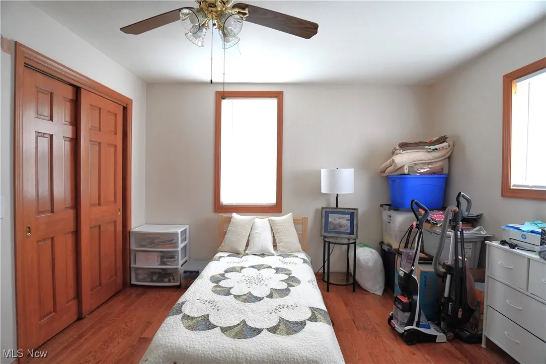 Bedroom featuring wood finished floors, ceiling fan, and a closet