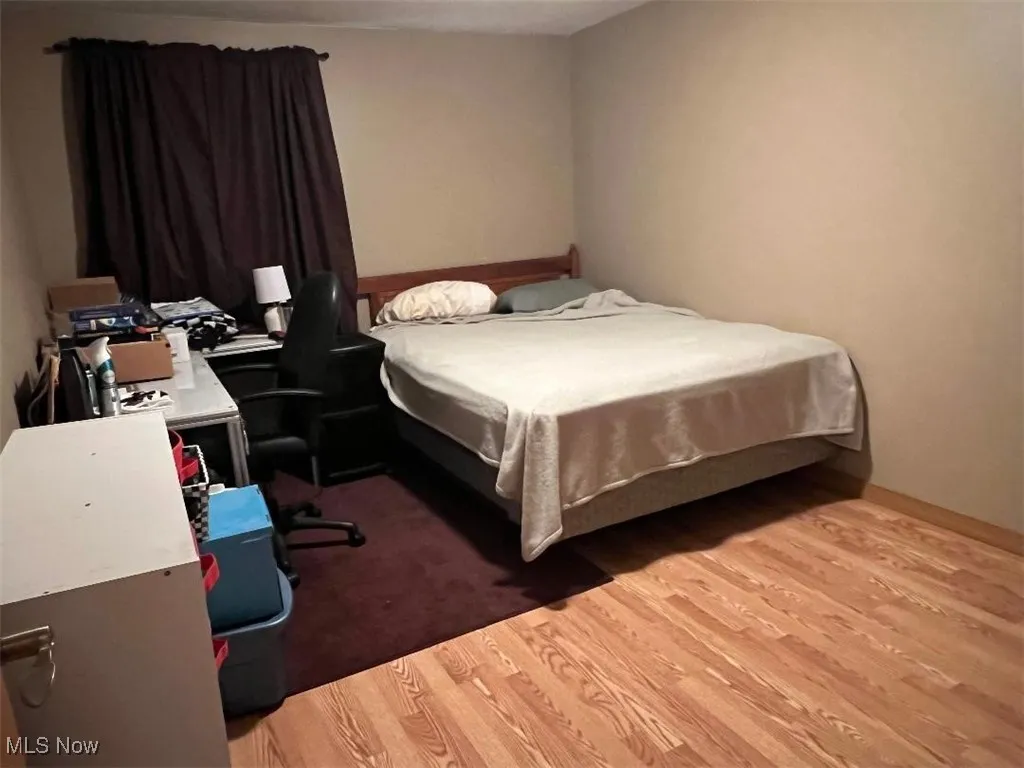 Bedroom featuring light laminate floors and a desk