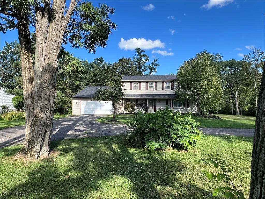 View of front of home featuring a spacious front yard,  circular drive, 2-car garage and add'l. parking pad for RV, boat, etc.!