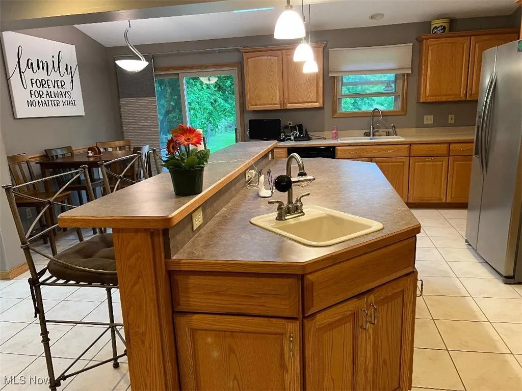 This island/breakfast bar provides storage, a countertop food prep area, sink and a seating area as well!