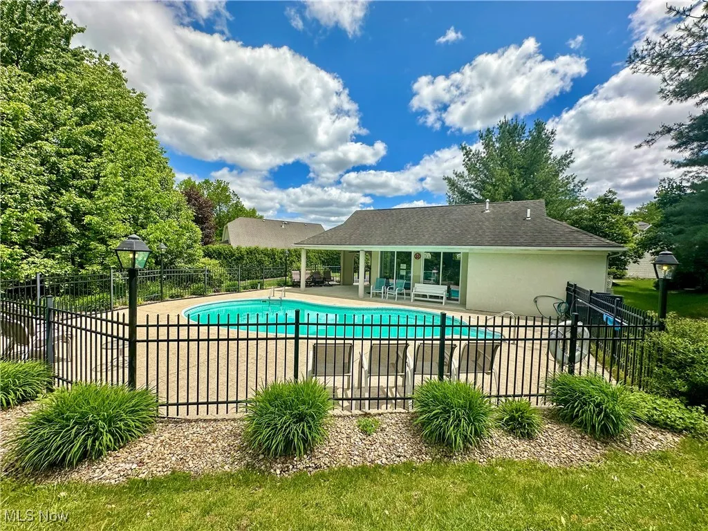 View of pool with a patio and fence
