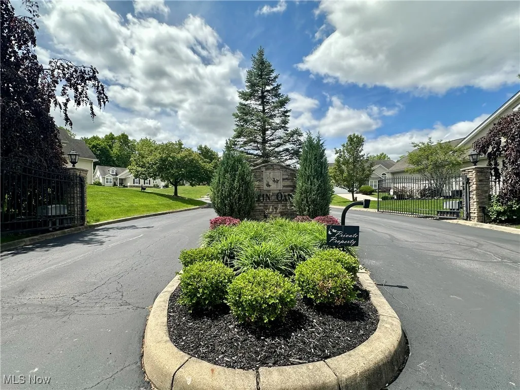 View of asphalt road featuring street lights, curbs, and a residential view