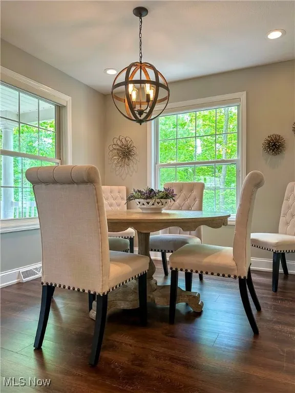 Dining room featuring a chandelier, wood finished floors, baseboards, and recessed lighting