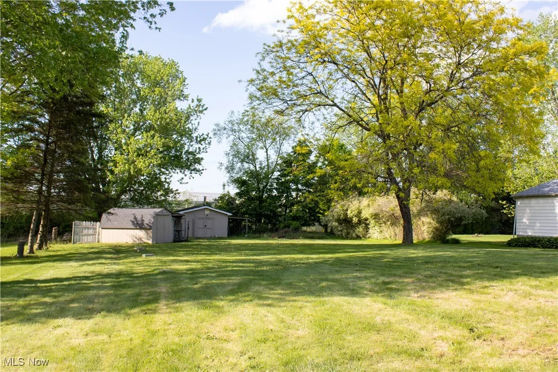 View of green lawn with an outdoor structure and a shed
