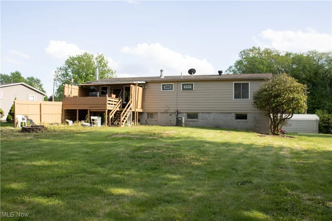 Back of house with stairs, a wooden deck, and central AC unit