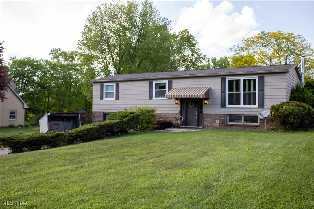 Split foyer home featuring a front lawn and brick siding
