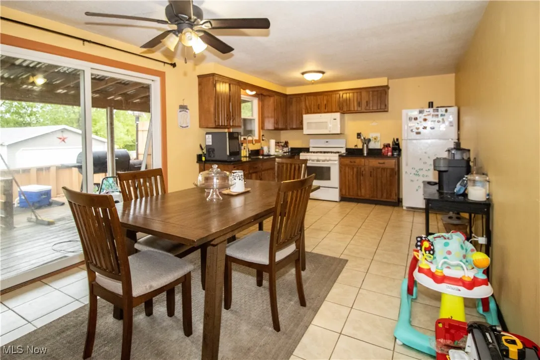 Dining room with light tile patterned flooring and ceiling fan