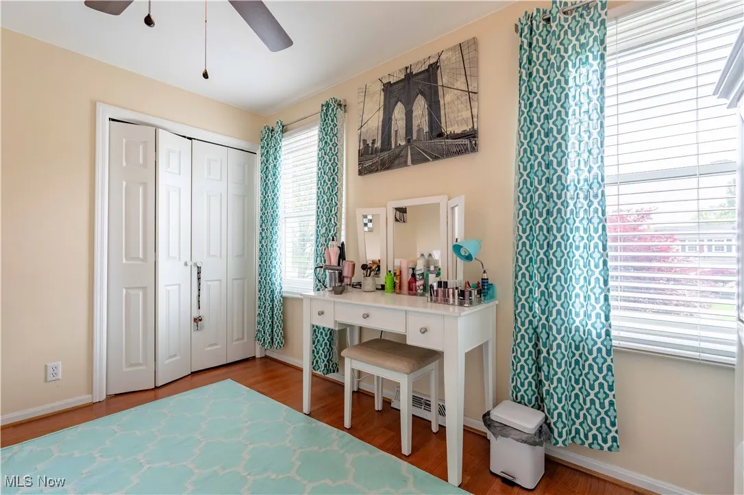 Bedroom featuring wood finished floors, baseboards, ceiling fan, and a closet