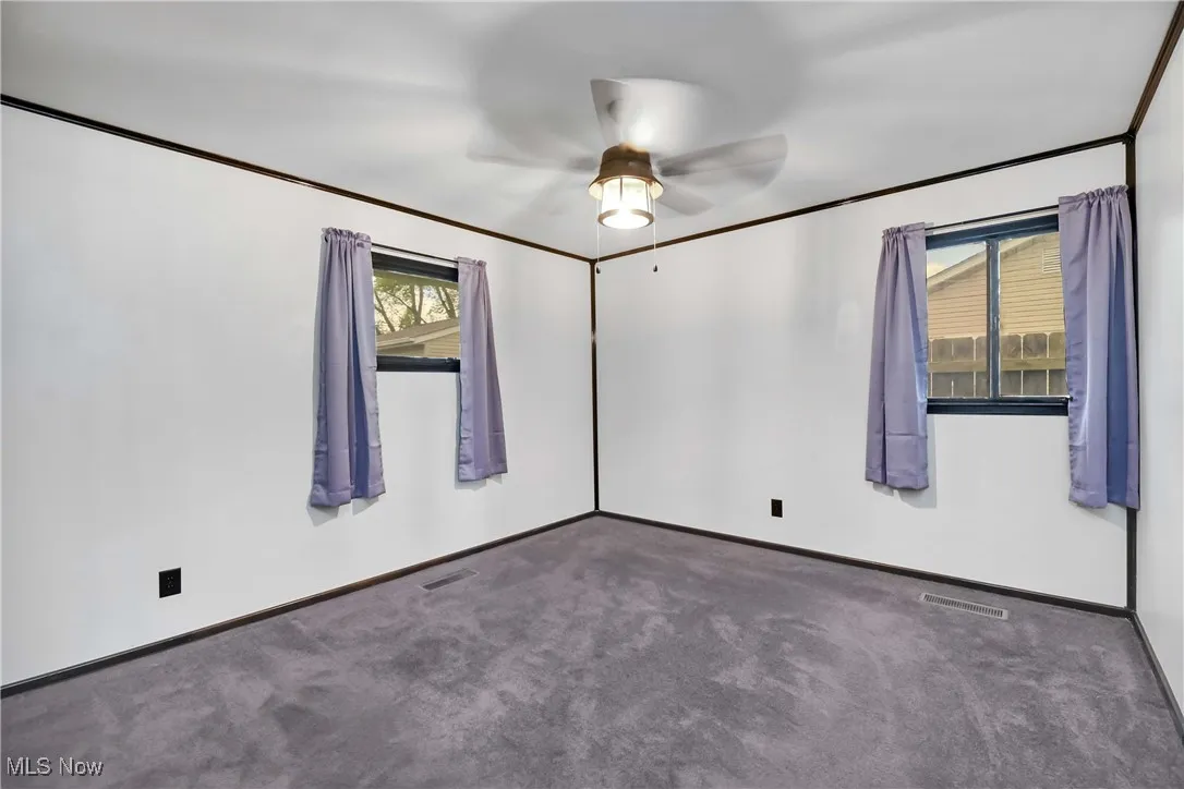 Unfurnished room with ceiling fan, carpet, and baseboards