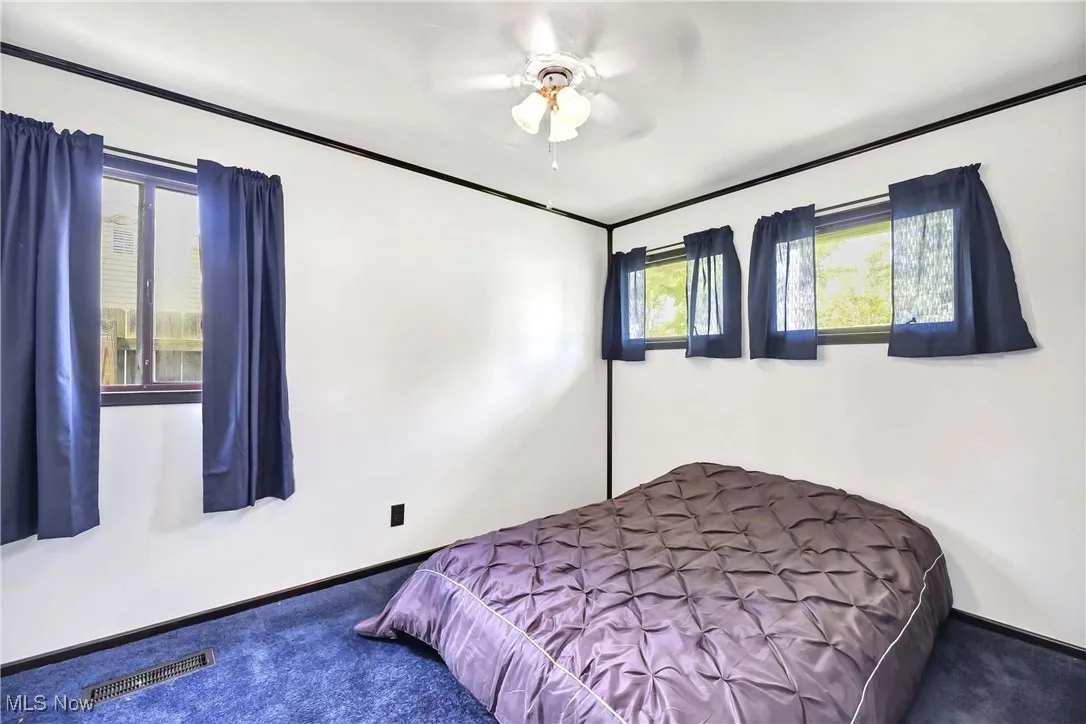 Bedroom with carpet, baseboards, and a ceiling fan